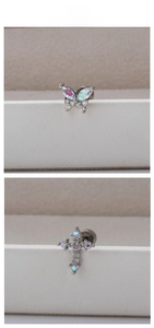 Detail of silver titanium steel earrings with butterfly and cross marquise zircon studs