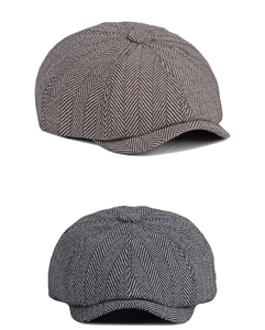 Detail of vintage striped newsboy caps in brown and grey with herringbone wool texture