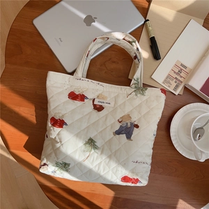 Quilted white cotton tote with cute bear pattern on a wooden desk lifestyle scene