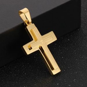 Macro shot of double-layered gold titanium cross pendant with engraved Lord's Prayer text