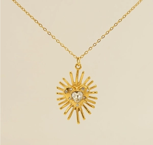 Gros plan du pendentif cœur tournesol doré avec cristal de zircon et détails pavés