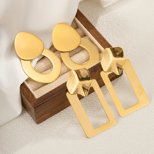 Minimalist gold stainless steel geometric hoop earrings set on professional linen jewelry display
