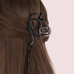 Elegant dark gunmetal snake-shaped hair claw clip on a stylish braided updo hairstyle