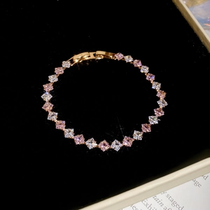 Close-up of gold-plated bracelet with pink and white cubic zirconia in black jewelry box