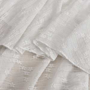 Gros plan sur le tissu en dentelle blanche avec motifs fins et texture voilée