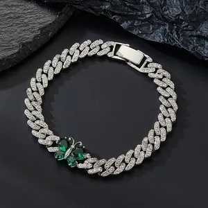 Close-up of Cuban link bracelet with emerald green stones and pavé set rhinestones