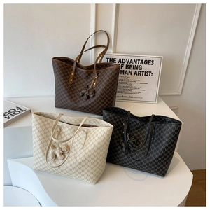 Tres bolsos tote grandes con monograma en marrón, beige y negro con dijes de elefante