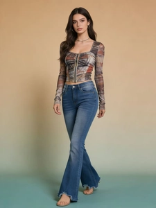 Detail of high waisted flared denim jeans with raw hem and mesh long sleeve crop top