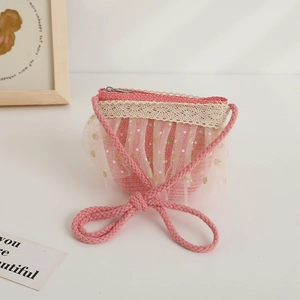 Gros plan d'un joli sac en paille rose avec dentelle et tulle à pois pour filles