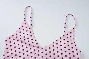 Detail of pink polka dot camisole with adjustable straps and deep V-neckline