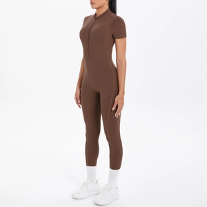 Detailed side view of a brown short-sleeve yoga jumpsuit with front zipper and slim fit