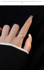 Detailed view of S925 silver camellia ring with zircon on model hand and black fabric