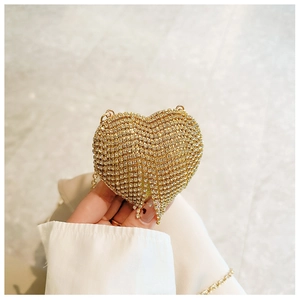 Close-up of a heart-shaped golden clutch with sparkling rhinestones and elegant tassels