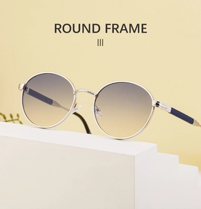 Detailed view of silver metal round frame sunglasses with gradient lenses and engraving