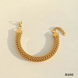 Close-up of gold V-shape woven bracelet with adjustable lobster clasp on beige texture