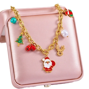 Golden Christmas bracelet with Santa, reindeer and tree charms on a pink jewelry box