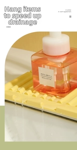 Close-up of yellow silicone sink mat with wave texture and water draining off surface