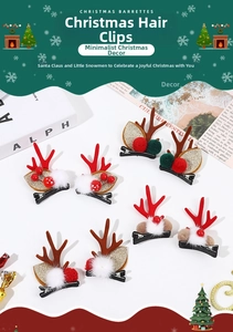 Détail de jolies barrettes de Noël en bois de renne avec pompons et paillettes