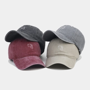 Close-up of four washed cotton baseball caps with cute embroidered puppy design