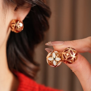 Vue détaillée des boucles d'oreilles boules florales vintage en émail rouge et crème