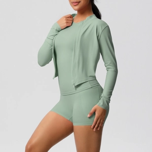 Détail d'un ensemble de yoga vert sauge avec veste ajustée et short de sport taille haute