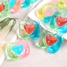 Colorful heart-shaped toilet cleaning gel beads in a white tray for bathroom freshness