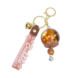 Pink and gold oil wind chime floating keychain with bubble wristlet and floral resin ball