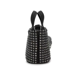 Vista lateral detallada del elegante bolso punk negro con tachuelas metálicas y calavera.