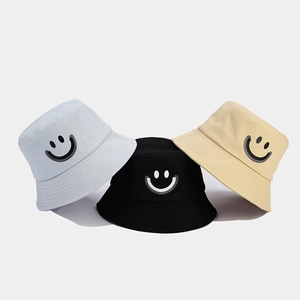 Detailed trio of cotton bucket hats in blue, black, and beige with smiley face embroidery