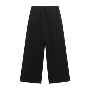 Dettaglio di pantaloni neri a gamba larga a costine con vita elastica su sfondo bianco