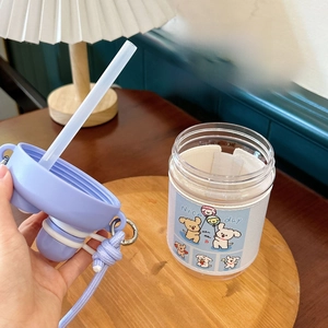 Close-up of portable purple water bottle with cute dog sleeve and wide mouth design