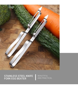 Detail of two stainless steel vegetable peelers on a wooden board with fresh ingredients
