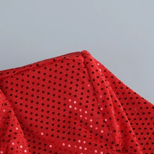Gros plan d'une robe à sequins rouges montrant les coutures et la texture brillante