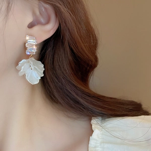 Detail of shell flower tassel earrings with zircons shown on a model side view