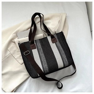 Macro detail of knit canvas texture on striped tote bag with leather strap