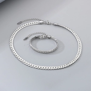 Detailed view of silver flat Cuban link necklace and bracelet set in polished finish