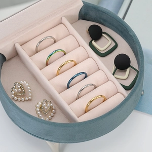 Green velvet round jewelry organizer box with soft pink lining and storage slots