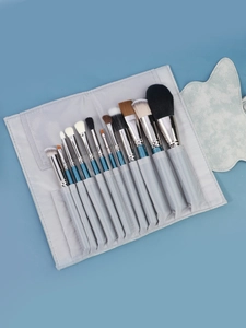 Dettaglio del set di 12 pennelli trucco blu glitterati con custodia grigia arrotolabile