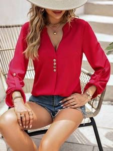 Elegante blusa roja con cuello en V y manga larga para mujer en un entorno exterior