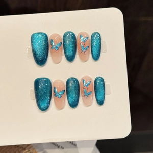 Blue cat-eye press-on nails with holographic butterfly stickers on white display card