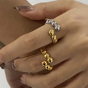 Polished stainless steel beaded open ring in gold and silver colors on hand