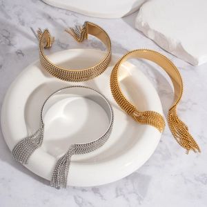 Détail des bracelets joncs à franges dorés et argentés sur un plateau en céramique
