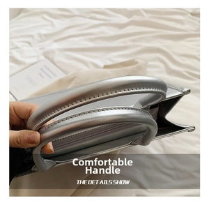 Detail of a metallic silver tote bag with reinforced handles and precise stitching