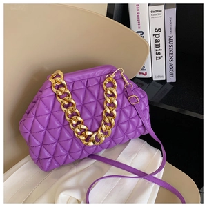 Detail view of purple quilted shell bag featuring thick gold chain and PU leather finish
