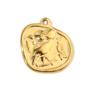 Macro view of gold-tone owl-embossed stainless steel pendant with Greek engraving