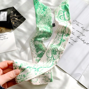 Detailed view of green and white French vintage silk scarf held by hand with floral pattern