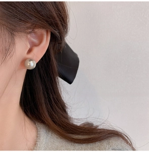 Silver-grey pearl stud earring shown on model with minimalist design and metallic luster
