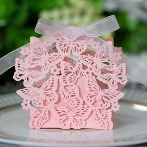 Pink laser-cut butterfly candy box with white ribbon bow and hollow paper design