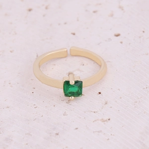 Macro detail of gold-plated open ring featuring a square green zircon in prong setting