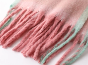 Macro detail of soft cashmere-like tassels showing pink and green gradient yarn